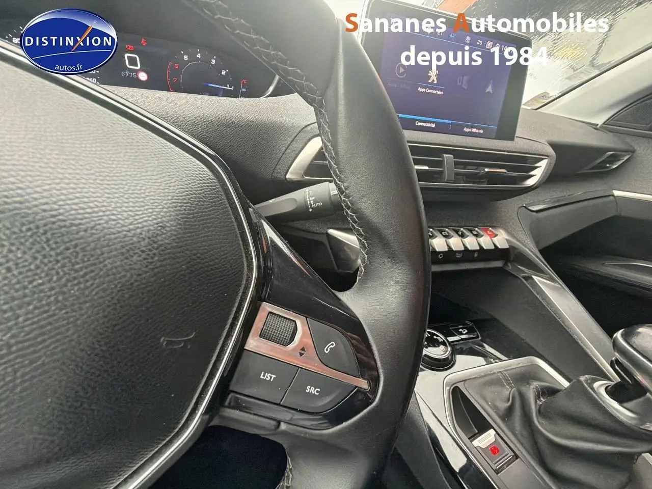 Vue intérieure centrée sur le volant cuir et la console centrale du Peugeot 3008 blanc, avec écran tactile et boîte manuelle.