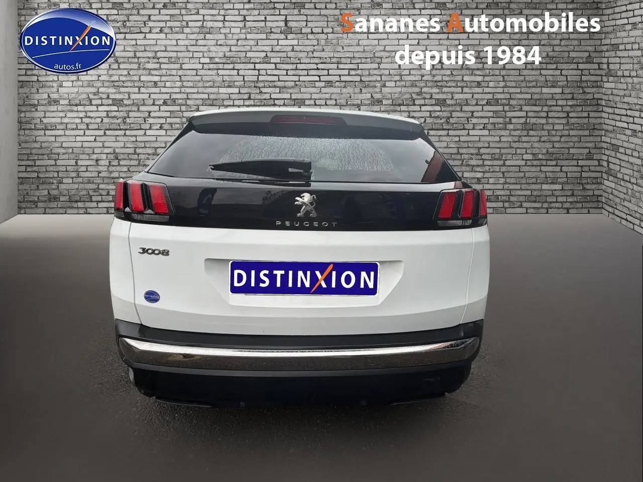 Vue arrière d’un Peugeot 3008 blanc nacré de 2020 avec bande noire et feux arrière à griffes rouges.