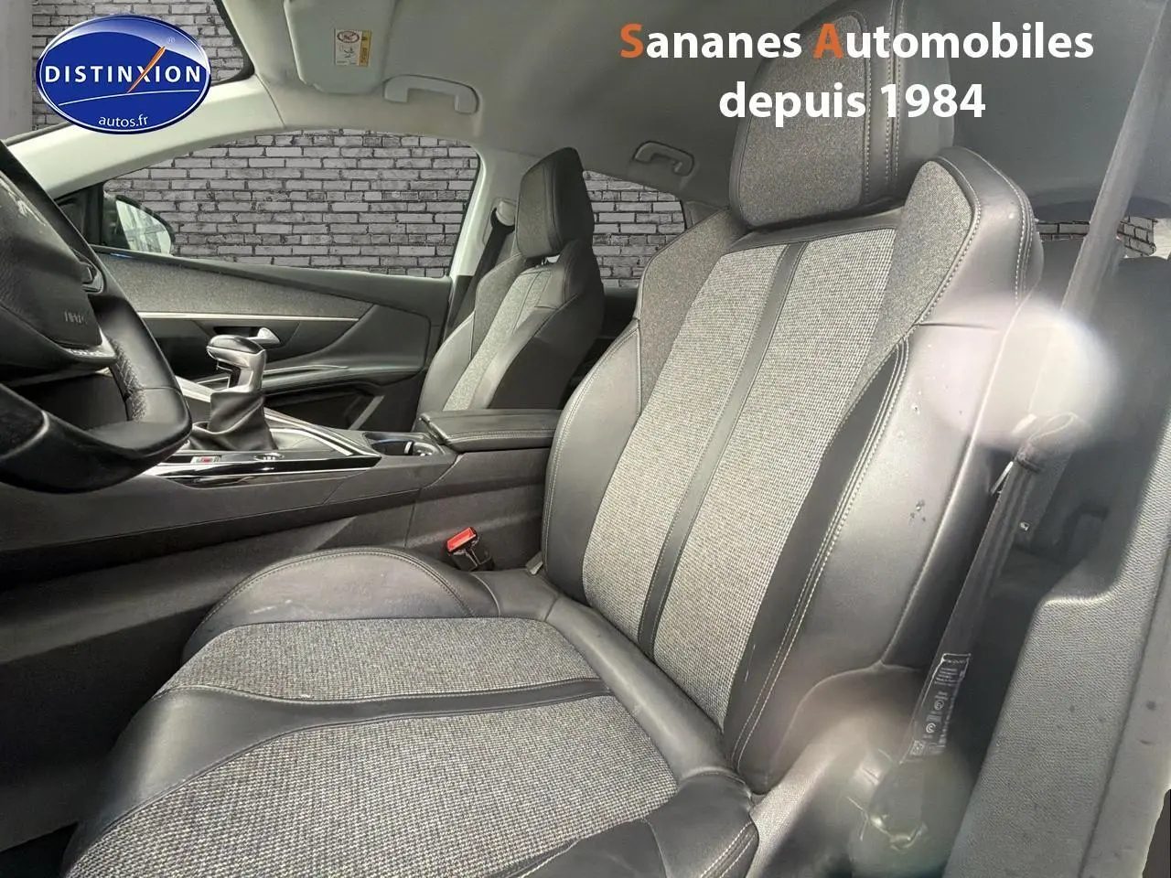 Vue intérieure côté conducteur du siège avant tissu et cuir du Peugeot 3008 blanc 2020 avec levier de vitesse manuel visible.