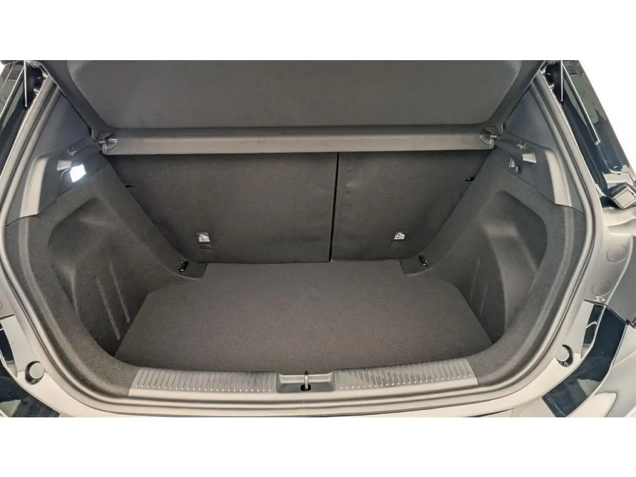 Coffre ouvert vu de l'arrière d'une MG3 1.5 Hybrid+ Cosmic Silver, intérieur noir et espace de rangement vide.