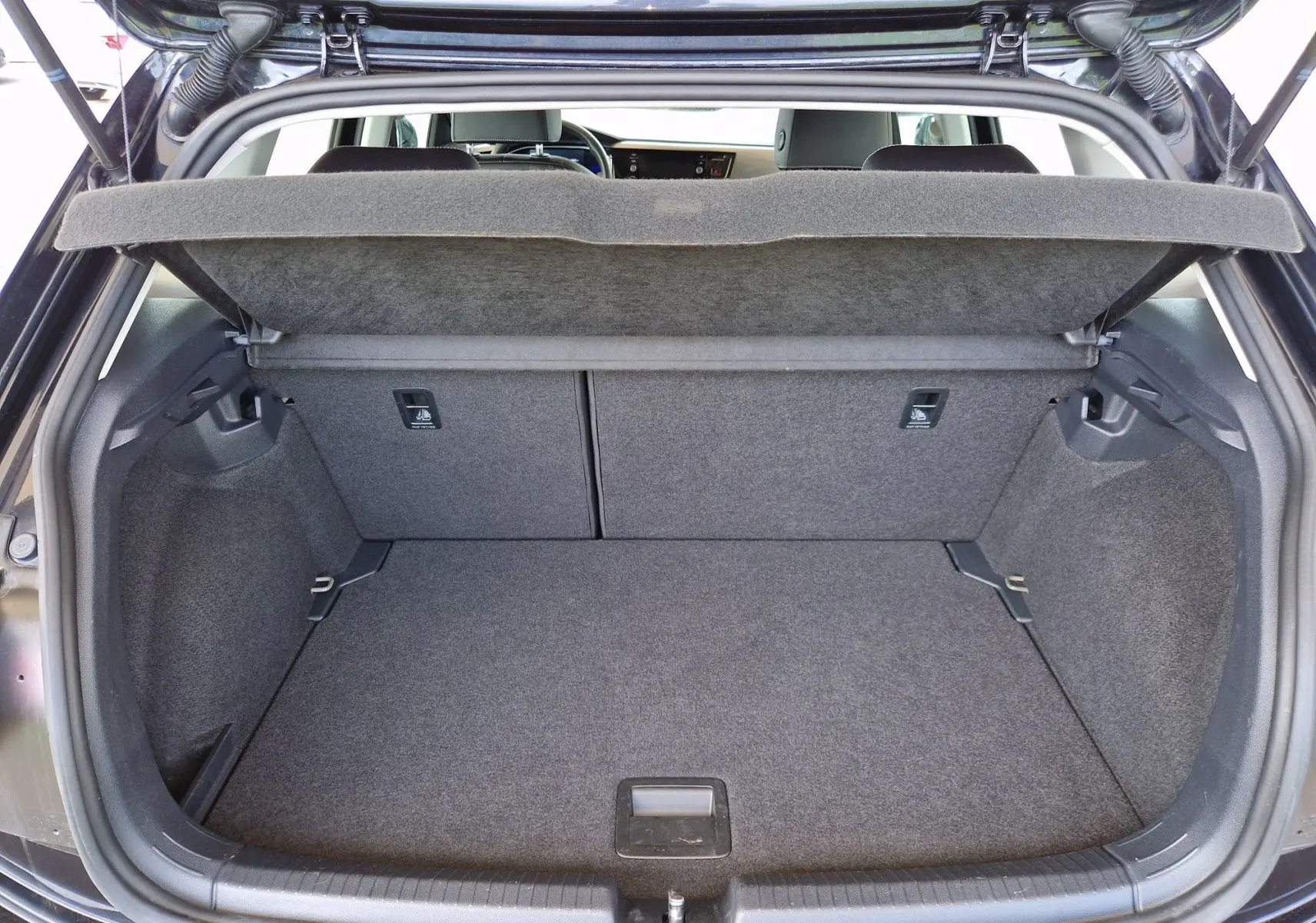 Coffre ouvert vu de l'arrière d'une Volkswagen Polo noire 2022, montrant un espace de chargement propre et vide.