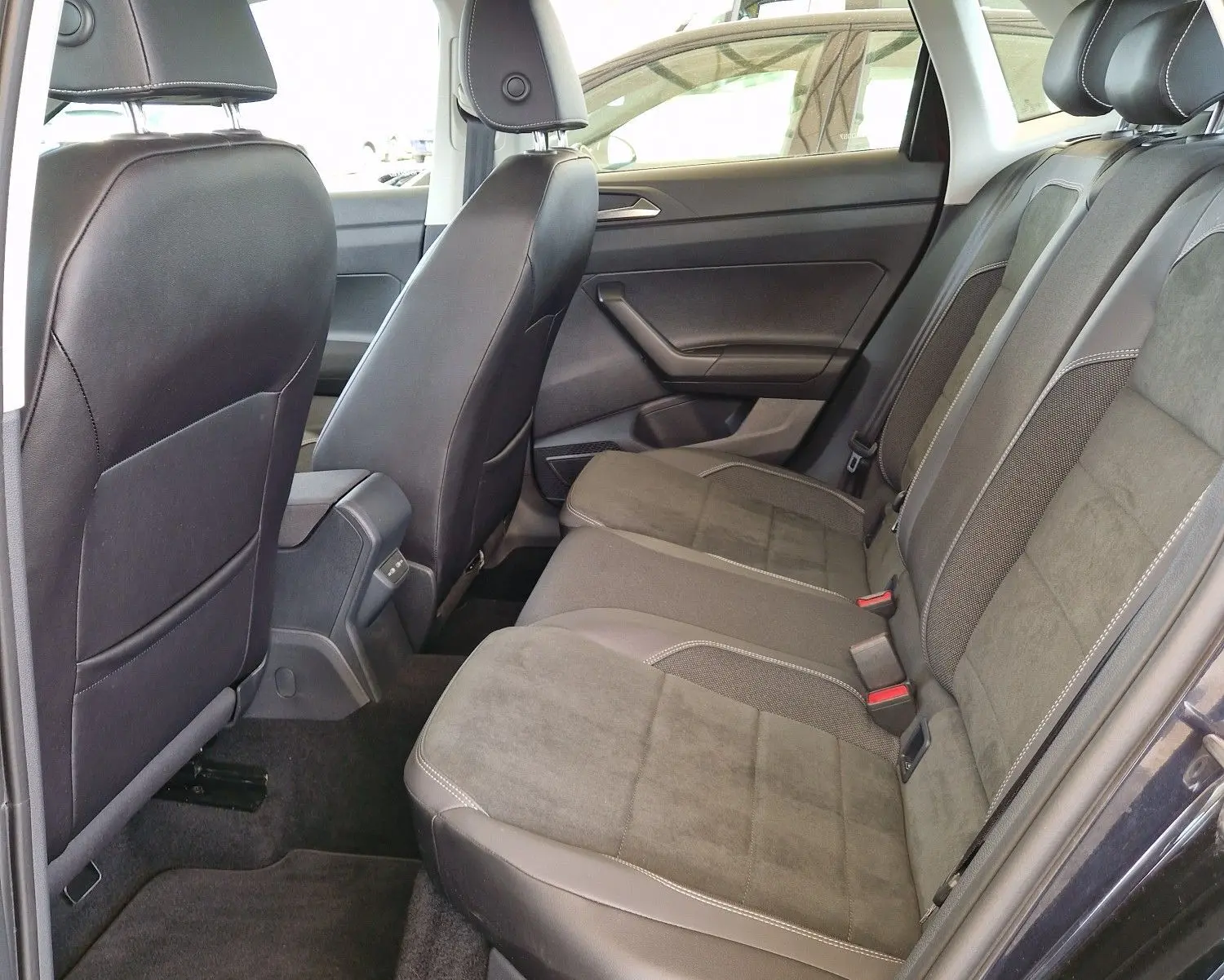 Vue intérieure côté droit des sièges arrière en tissu et cuir gris d'une Volkswagen Polo noire 2022 avec toit ouvrant.