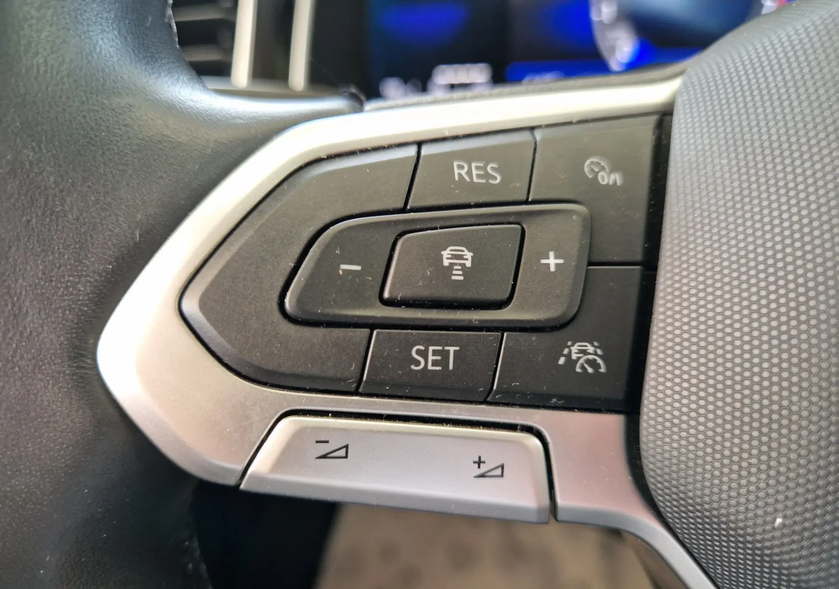 Gros plan sur les commandes de régulateur de vitesse au volant d'une Volkswagen Polo noire de 2022.