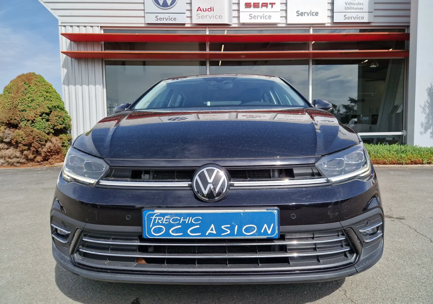 Vue frontale d'une Volkswagen Polo noire 2022 avec plaque d'occasion et calandre chromée visible.