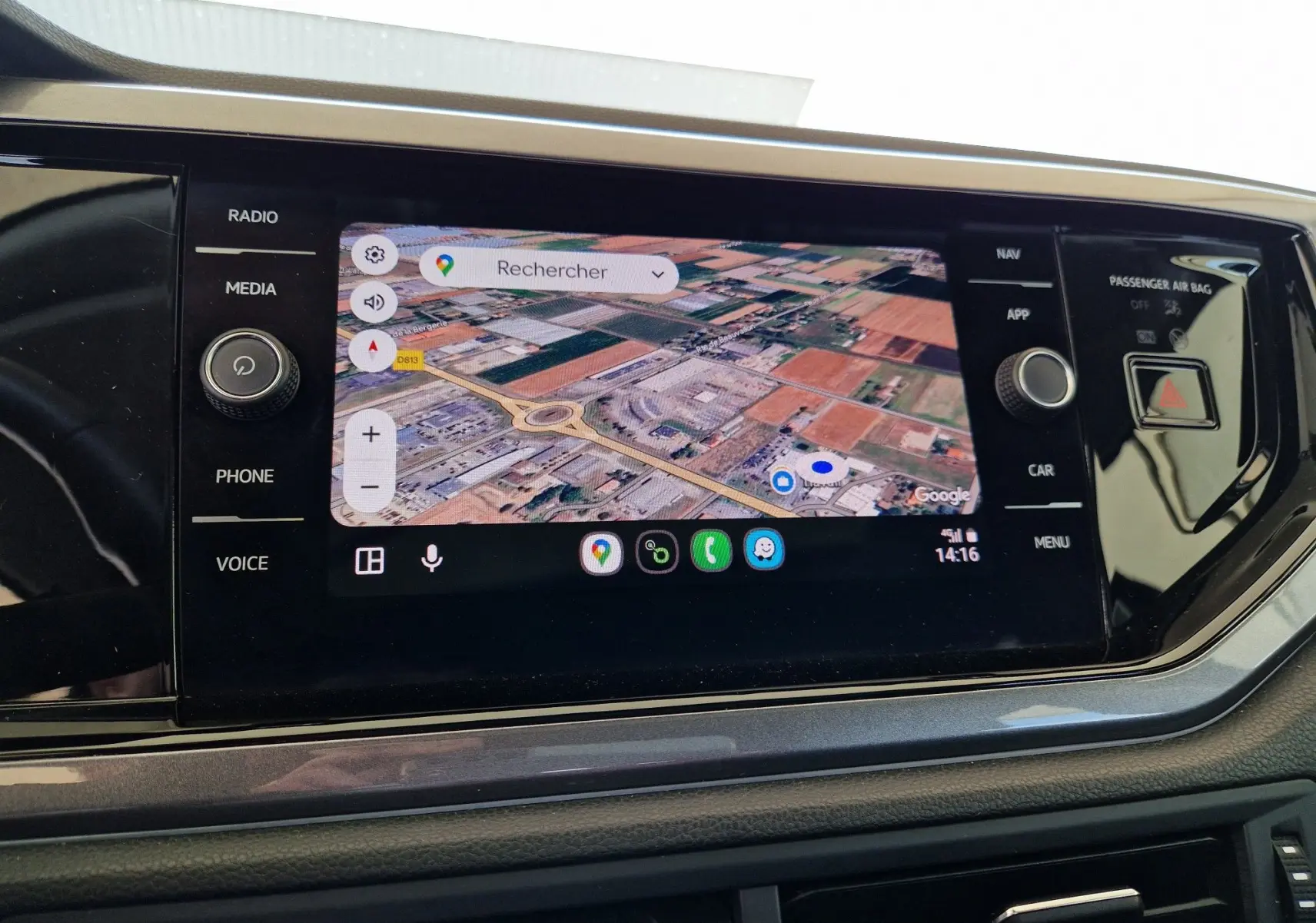 Écran tactile central de la Volkswagen Polo 2022 montrant une carte GPS en vue satellite avec commandes autour.