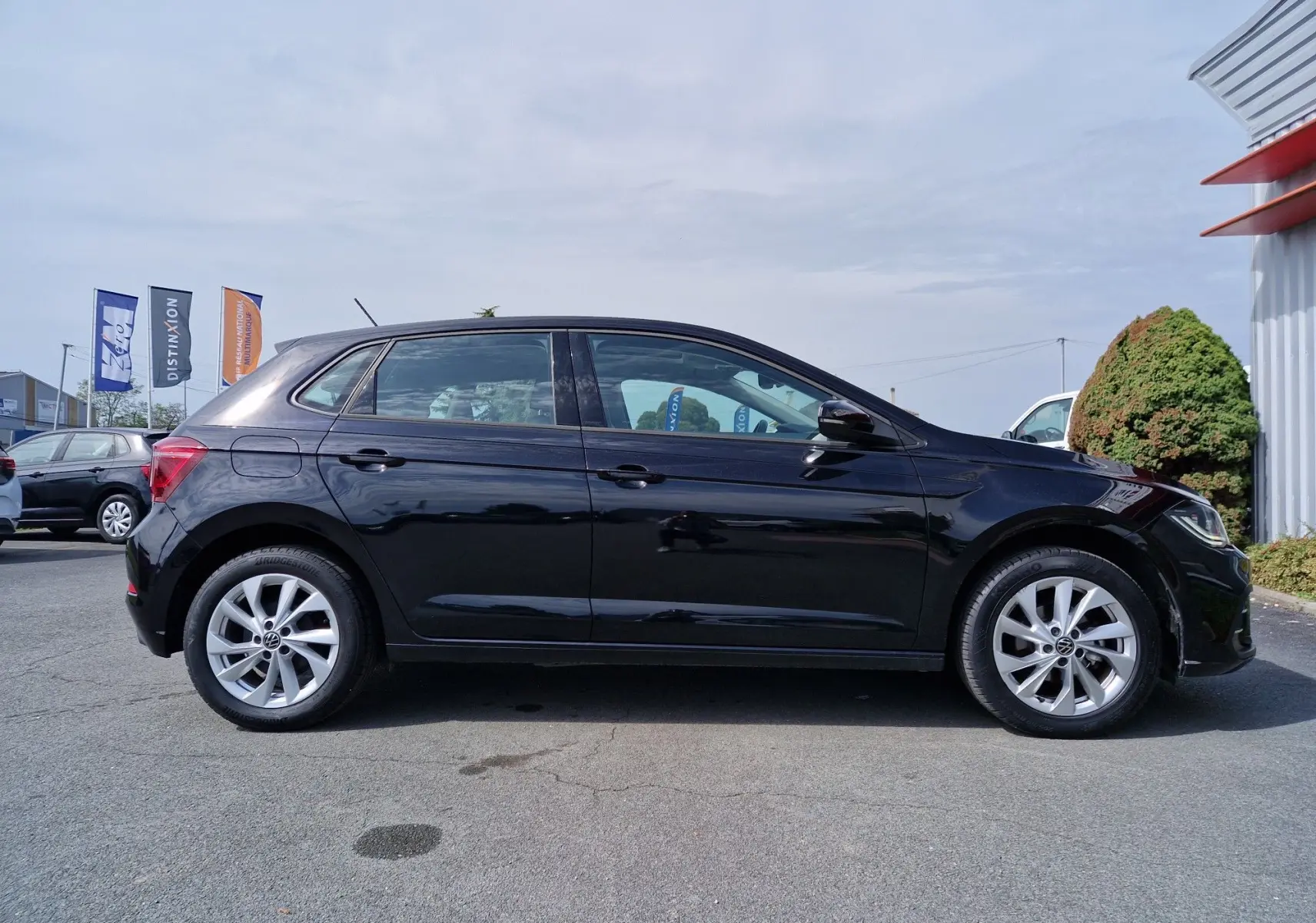 Profil côté gauche d'une Volkswagen Polo noire 2022 avec jantes alliage et carrosserie lisse brillante.