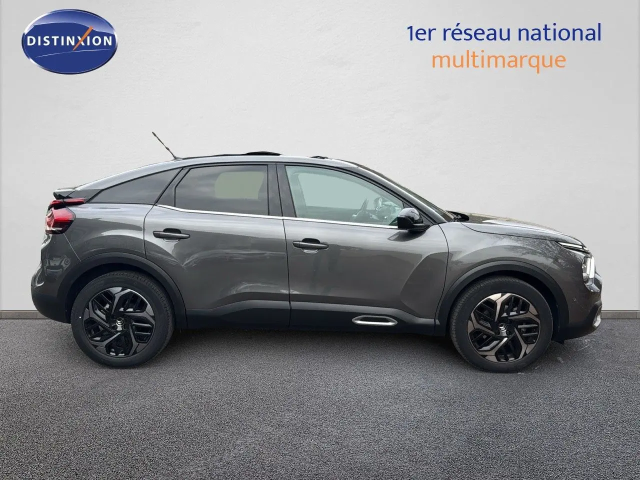 Profil côté gauche d'une Citroën C4 2021 gris avec toit noir et jantes noires bicolores, toit ouvrant visible.