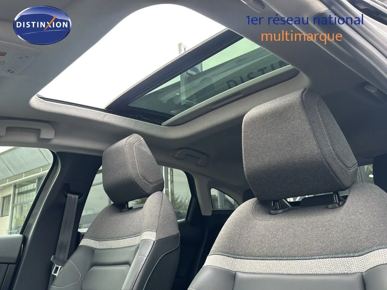 Intérieur de la Citroën C4 2021 avec toit ouvrant, sièges tissu gris et cuir noir vus de l'avant côté conducteur.