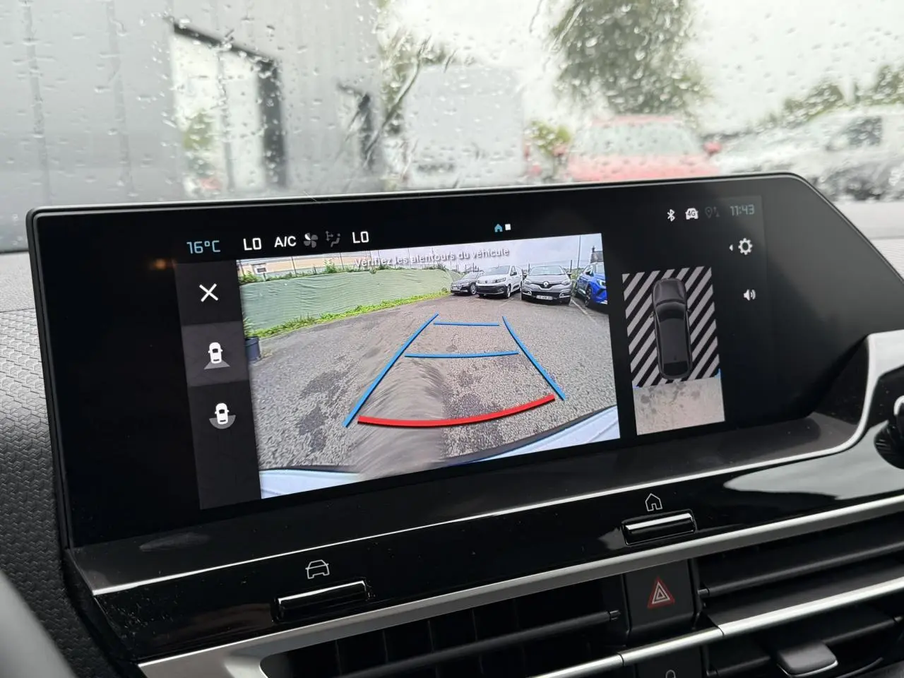 Écran tactile intérieur affichant la caméra de recul et l'aide au stationnement du Citroën C4 blanc Okénite avec toit noir.