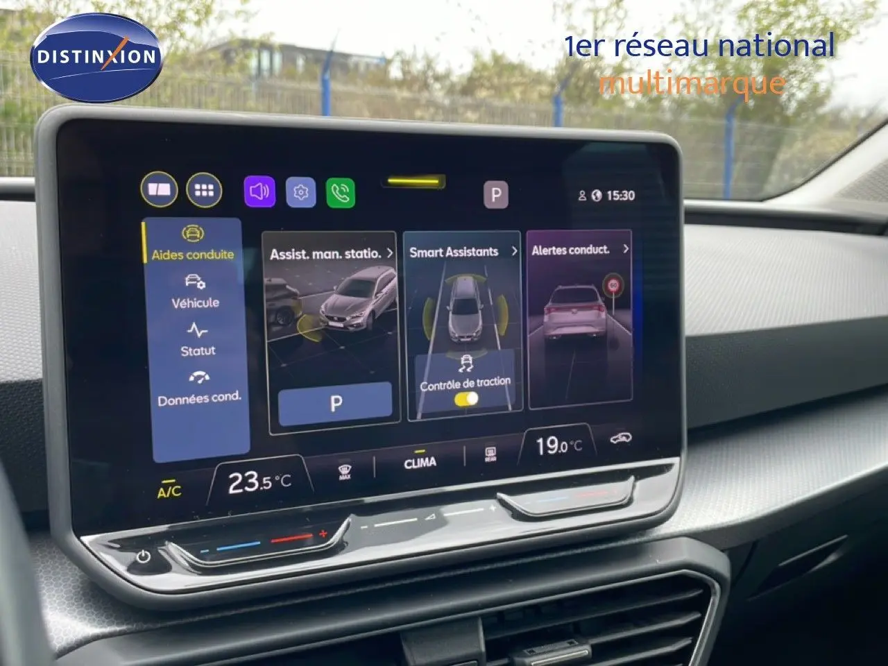 Écran tactile central affichant les aides à la conduite dans l’habitacle d’une SEAT LEON ST gris magnétique, vue de face.