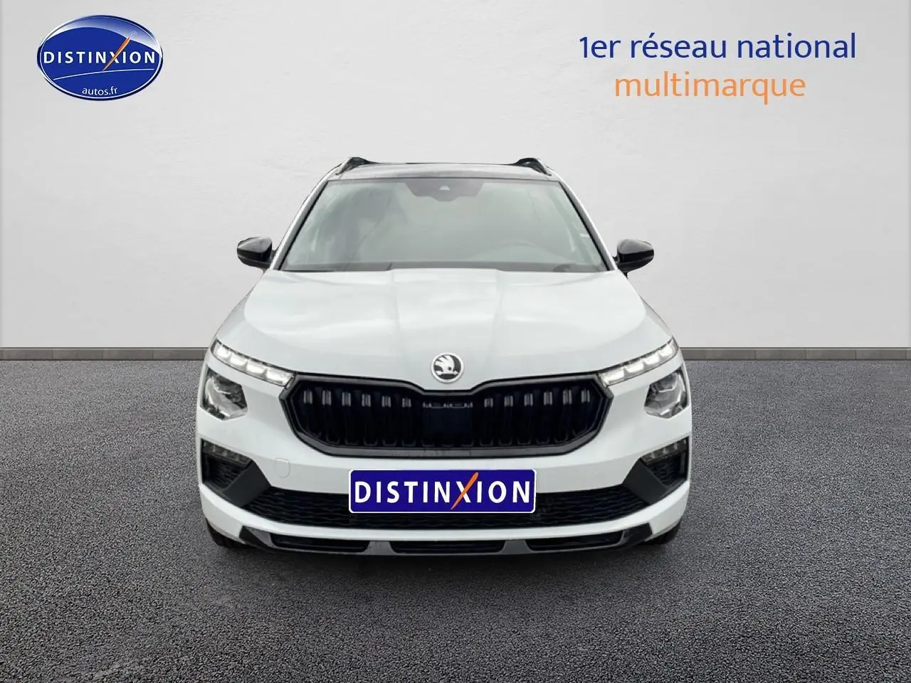 Vue frontale d’un Skoda Kamiq blanc nacré avec calandre noire et phares LED distinctifs.