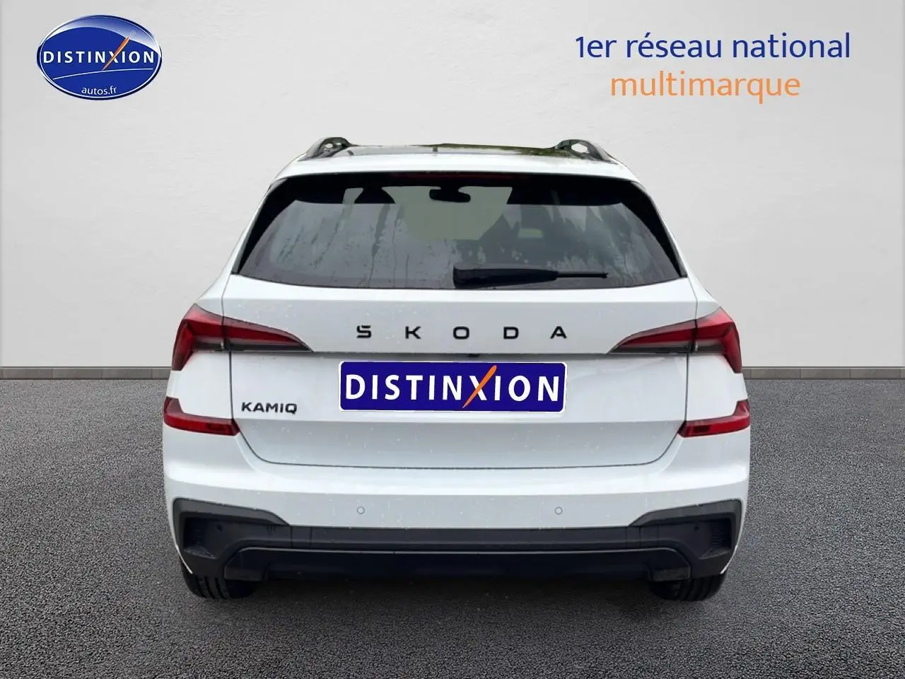 Vue arrière d'un Skoda Kamiq blanc nacré avec feux LED et diffuseur noir, sur fond neutre gris.