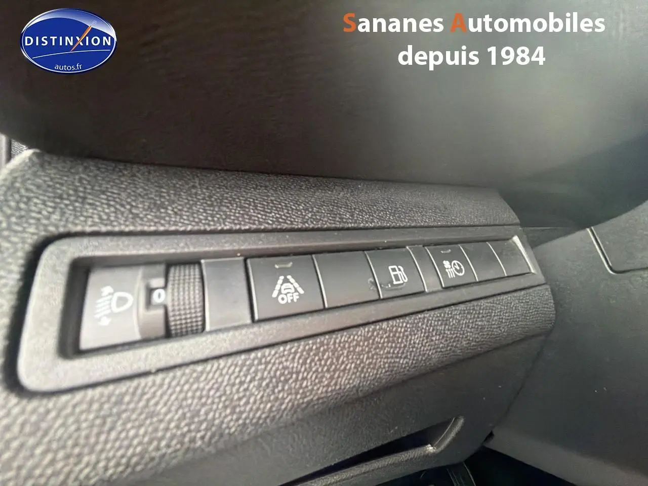 Gros plan sur les commandes de réglage et aides à la conduite du tableau de bord d'un Peugeot 3008 Hybrid blanc.