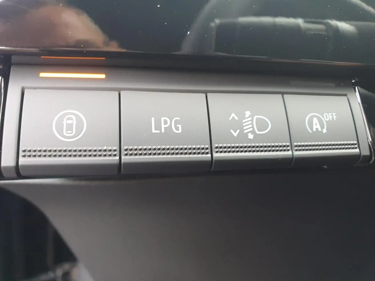 Gros plan sur les boutons de commande intérieurs de la Renault Clio VI noire, dont le bouton LPG pour la bicarburation.