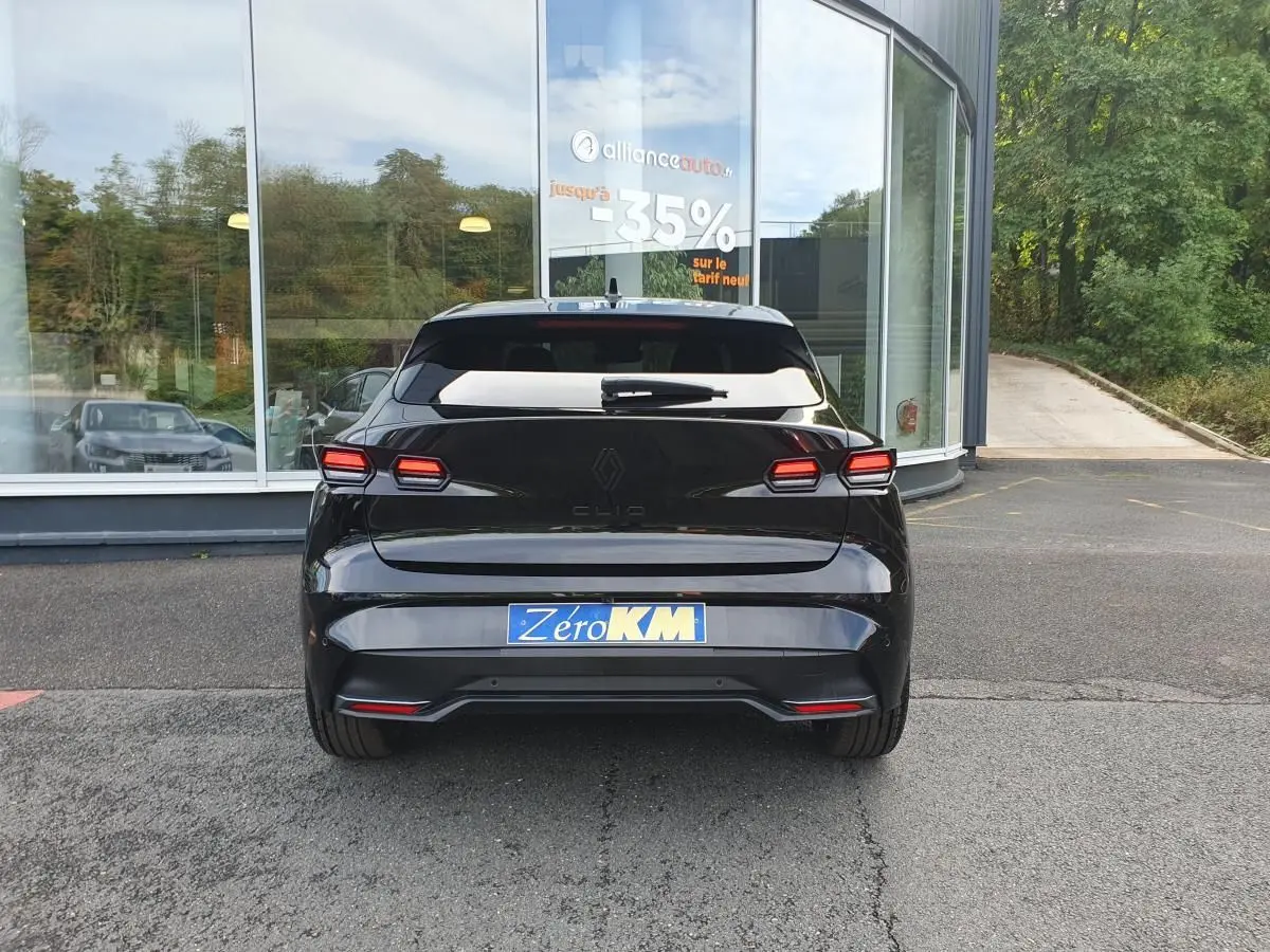 Vue arrière d'une Renault Clio VI noire étoile, avec feux LED distinctifs et vitres arrière surteintées.