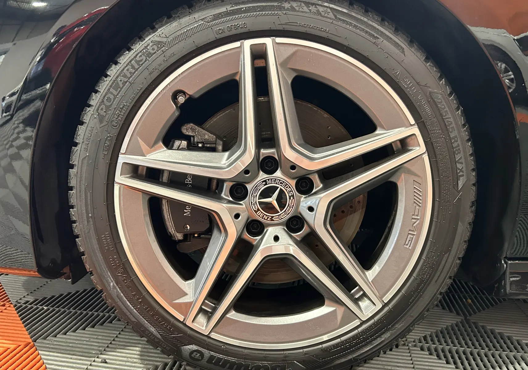 Gros plan sur la jante AMG argentée et le pneu noir d'une Mercedes CLA Shooting Brake noire métallisée.