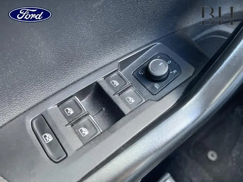 Gros plan sur les commandes des vitres et rétroviseurs côté conducteur d'une Volkswagen Polo Reflet d'Argent 2022.