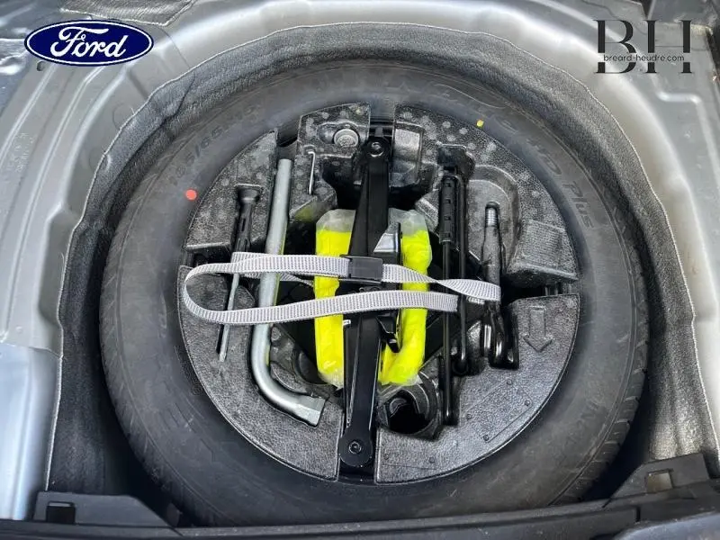 Gros plan sur la roue de secours et son kit d'outils dans le coffre d'une Volkswagen Polo 1.0 TSI 95ch R-Line argent métallisé.