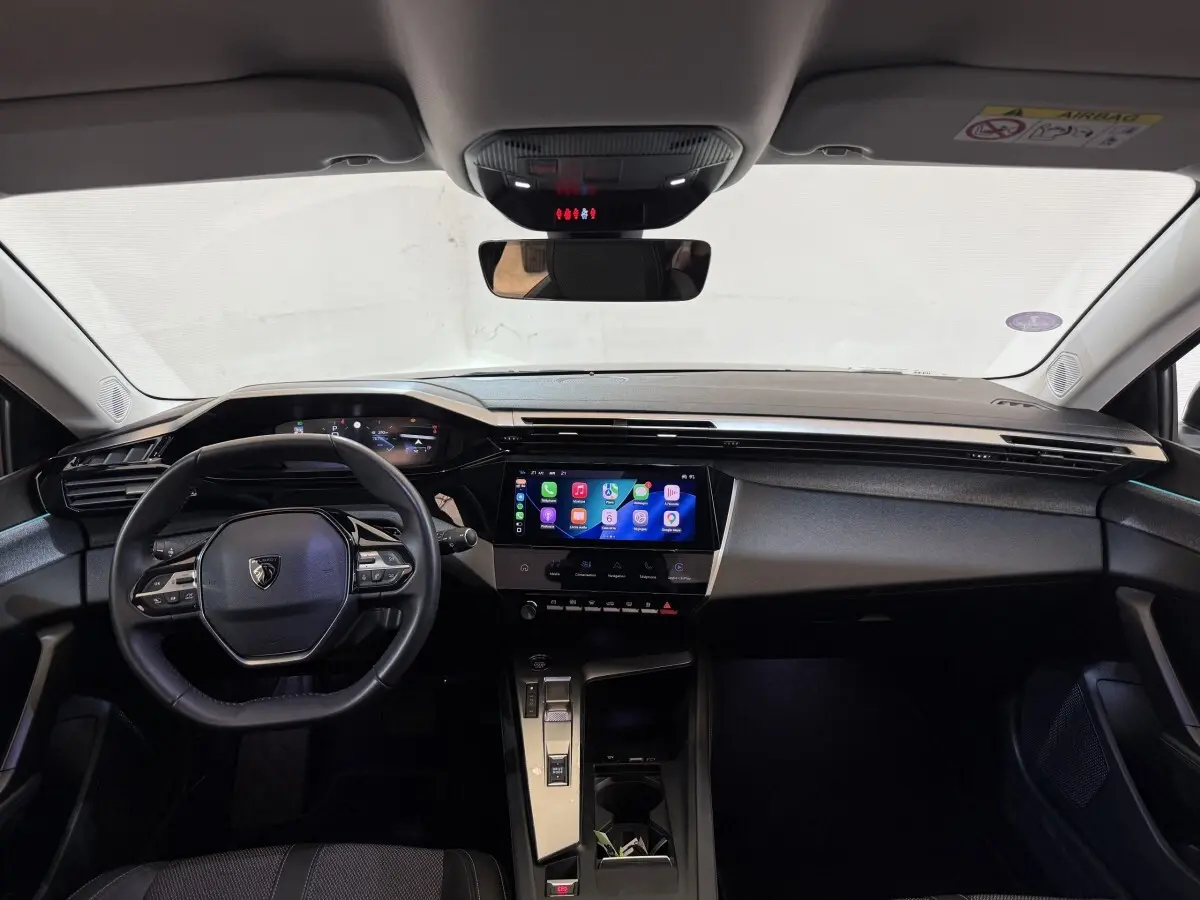 Vue intérieure avant du tableau de bord de la Peugeot 308 2022, avec écran tactile central et volant multifonctions cuir.