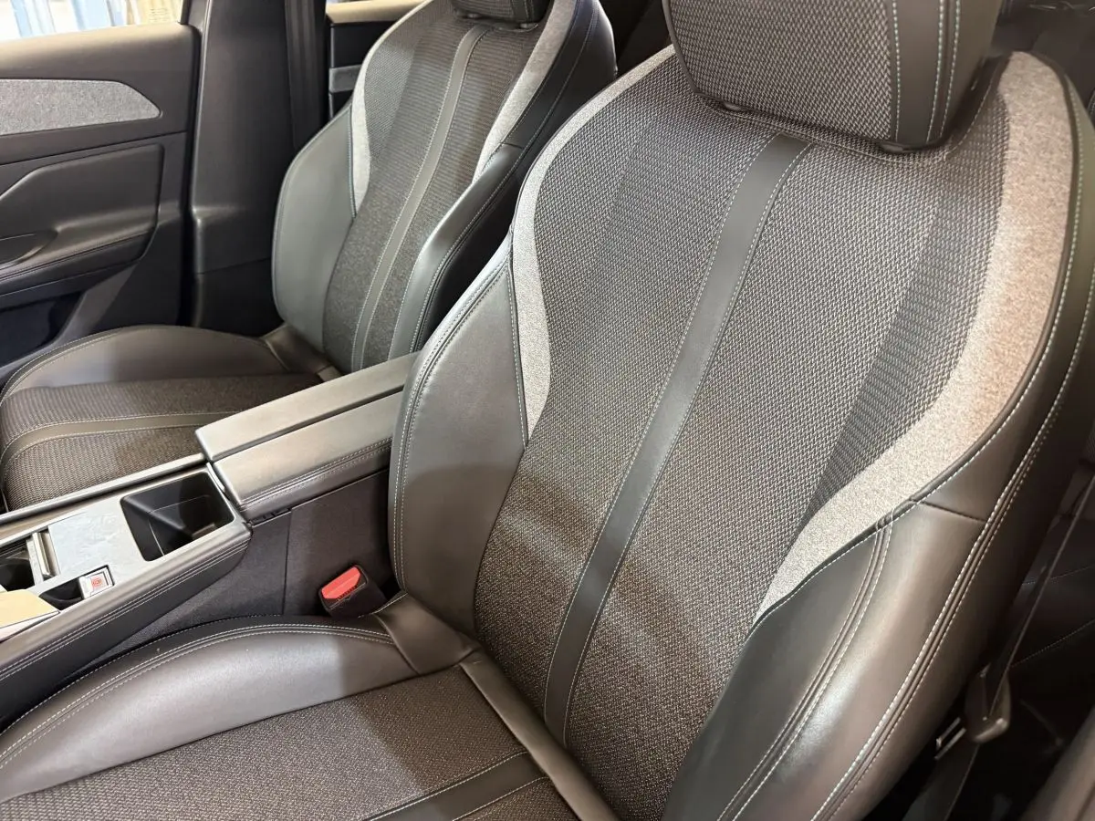 Gros plan sur les sièges avant en tissu et cuir gris foncé de la Peugeot 308 SW Allure Pack 2022.