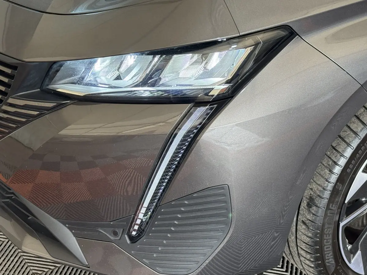 Gros plan sur le phare avant droit gris foncé du Peugeot 308 SW avec éclairage LED et détails du pare-chocs.