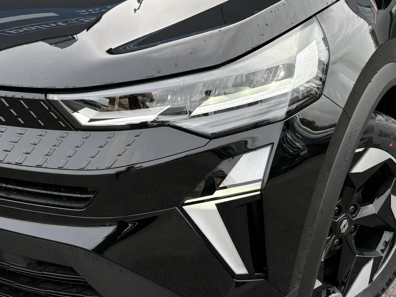 Gros plan sur l'avant droit noir étoilé du Renault Captur 2025 avec ses phares LED et jantes aluminium noires.