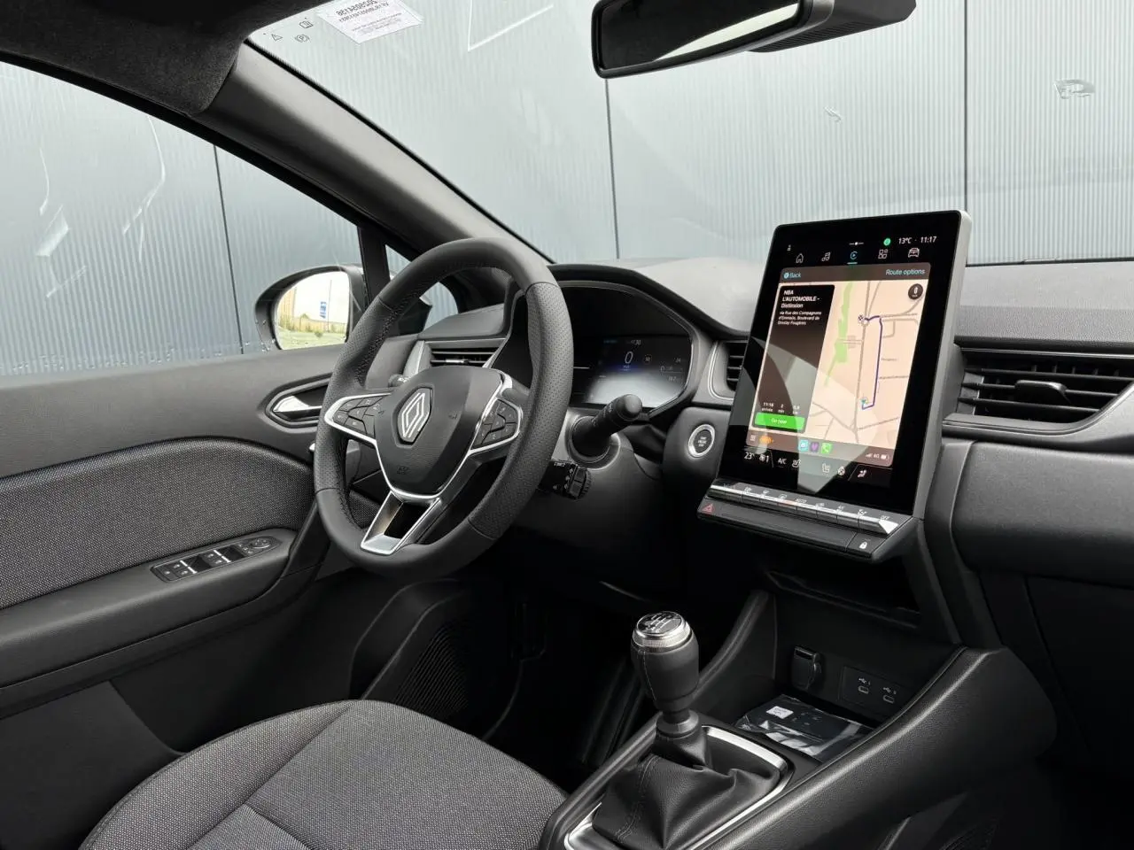 Intérieur côté conducteur du Renault Captur 2025 avec volant multifonction, boîte manuelle et écran tactile vertical Open R-Link 10 pouces.