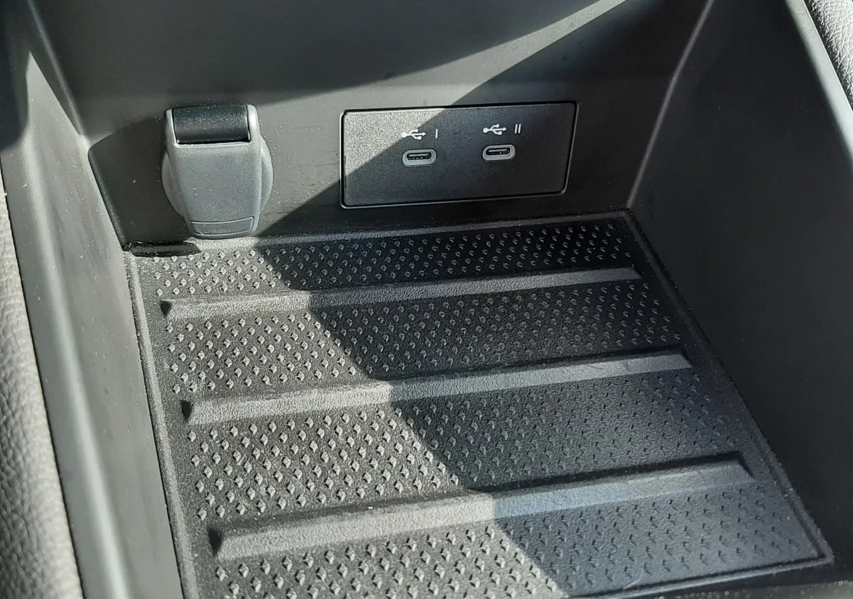 Gros plan sur la console centrale noire du Renault Captur 2024, montrant deux ports USB-C et une prise 12V.