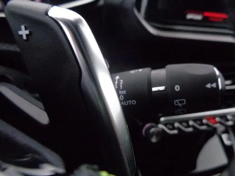 Gros plan sur la palette de changement de vitesse droite en aluminium du Peugeot 2008 gris Artense, avec commandes au volant visibles.