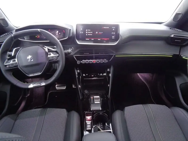 Intérieur avant du Peugeot 2008 2023 avec tableau de bord noir, volant cuir compact et écran tactile central.