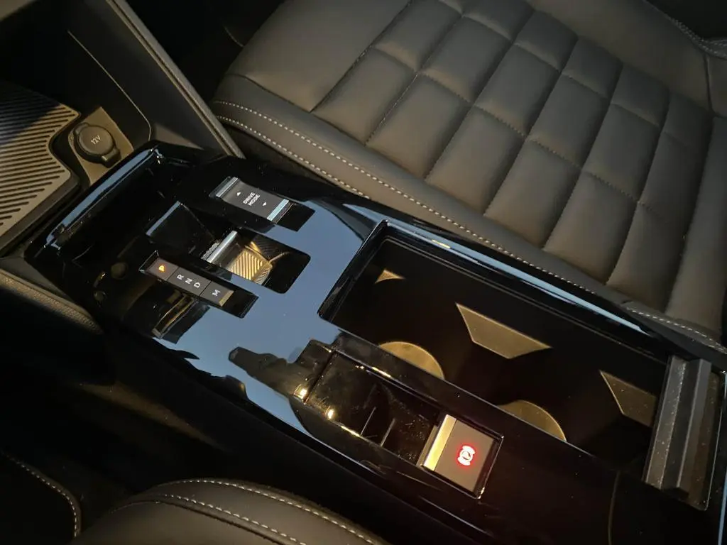 Vue rapprochée de la console centrale noire brillante avec levier de boîte auto et siège en cuir gris foncé du Citroën C4 2025.