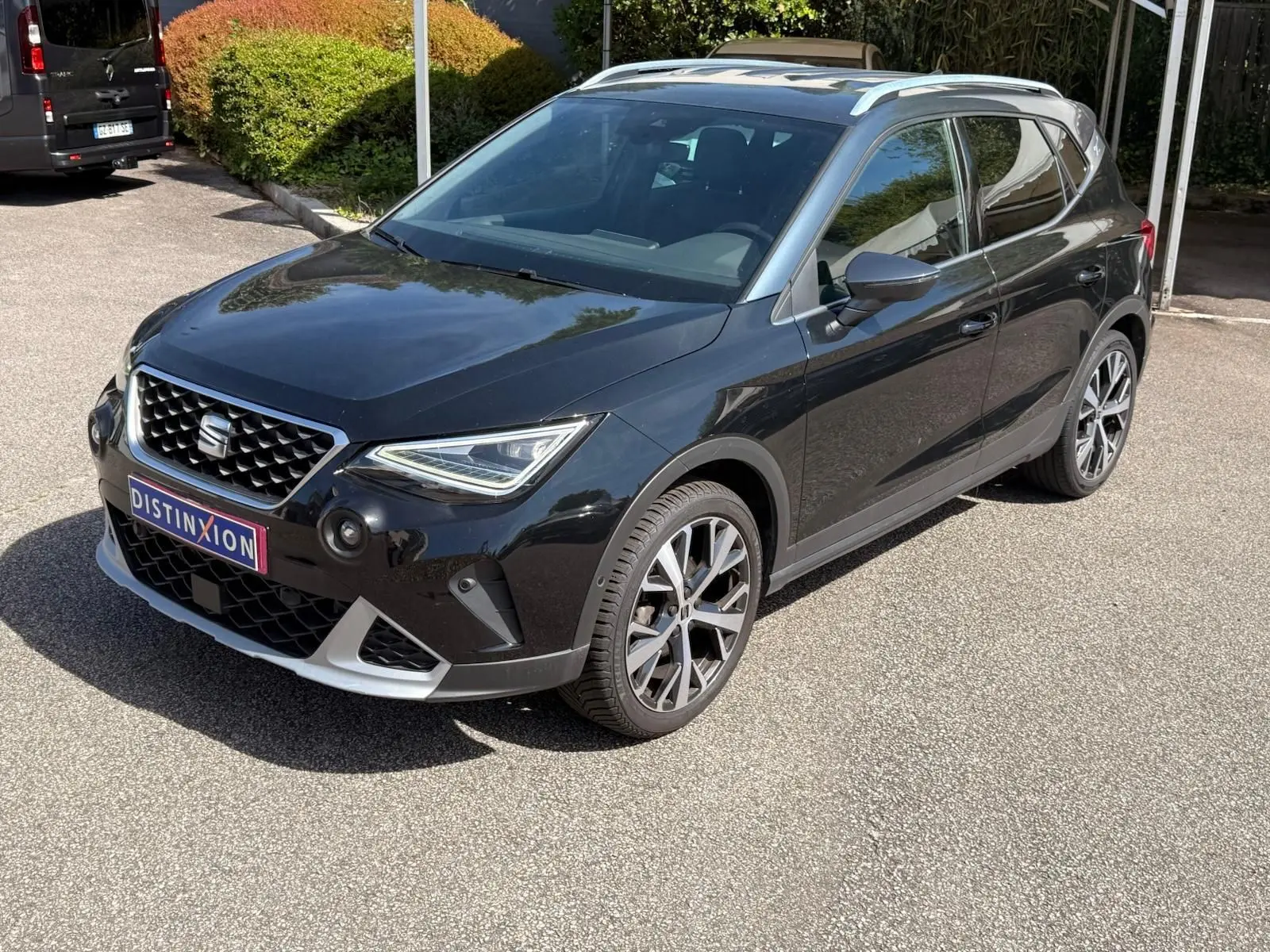 SEAT Arona noir vue 3/4 avant droit, avec jantes alliage et toit argenté sous soleil.