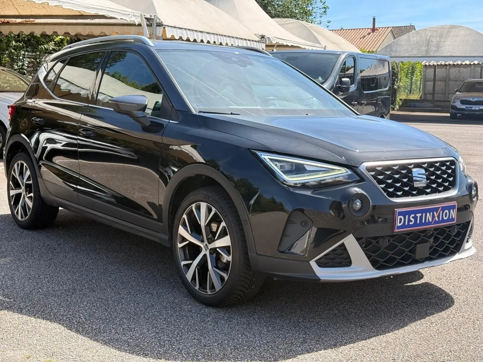 Vue 3/4 avant droite d'une SEAT Arona noire avec jantes alliage et calandre distinctive FR Xclusive.