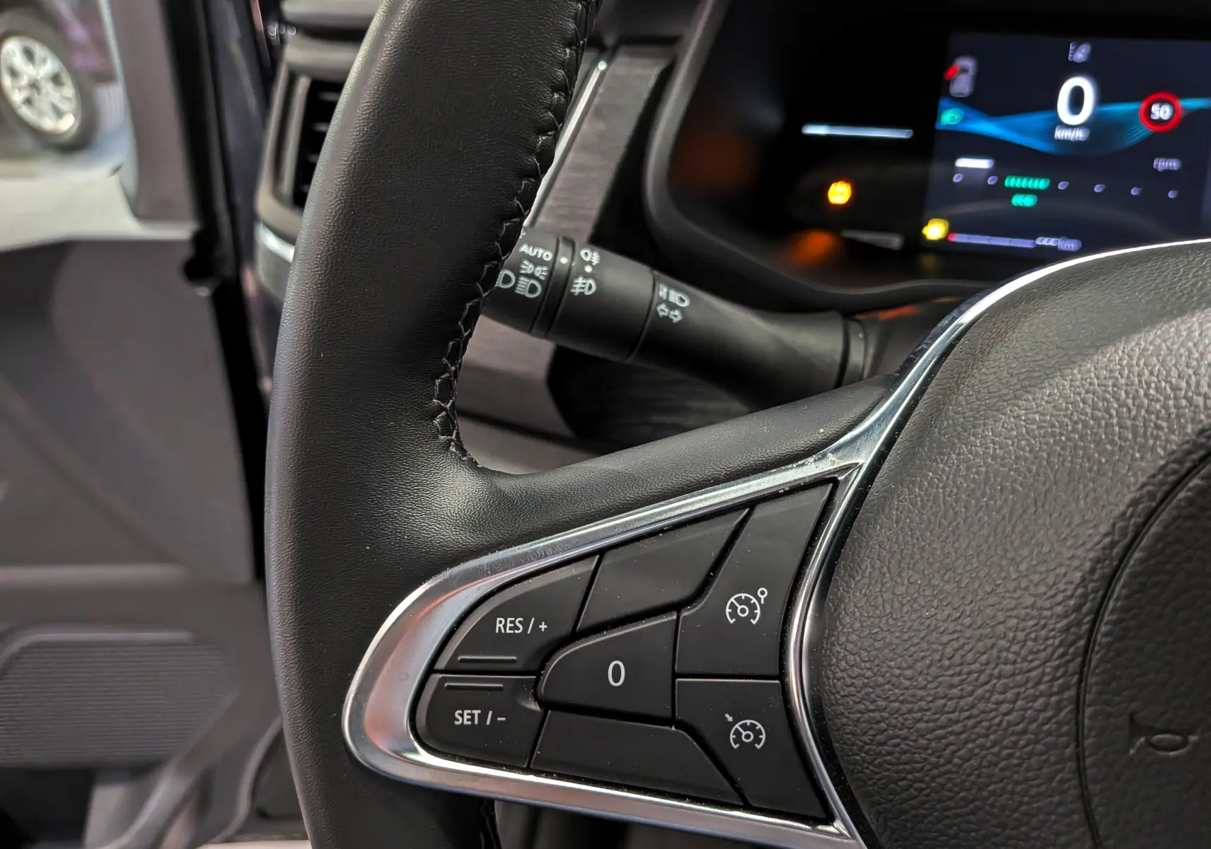 Gros plan sur le volant noir du Nissan Primastar Combi 2025, avec commandes de régulateur de vitesse visibles.