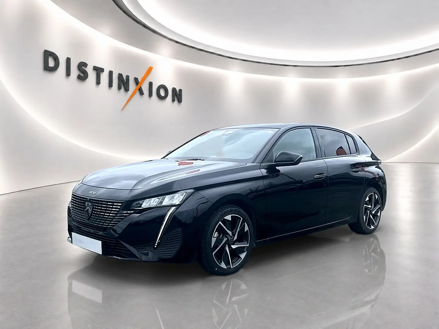 Peugeot 308 noire vue en 3/4 avant droit, avec phares LED et jantes alliage distinctives dans un showroom lumineux.