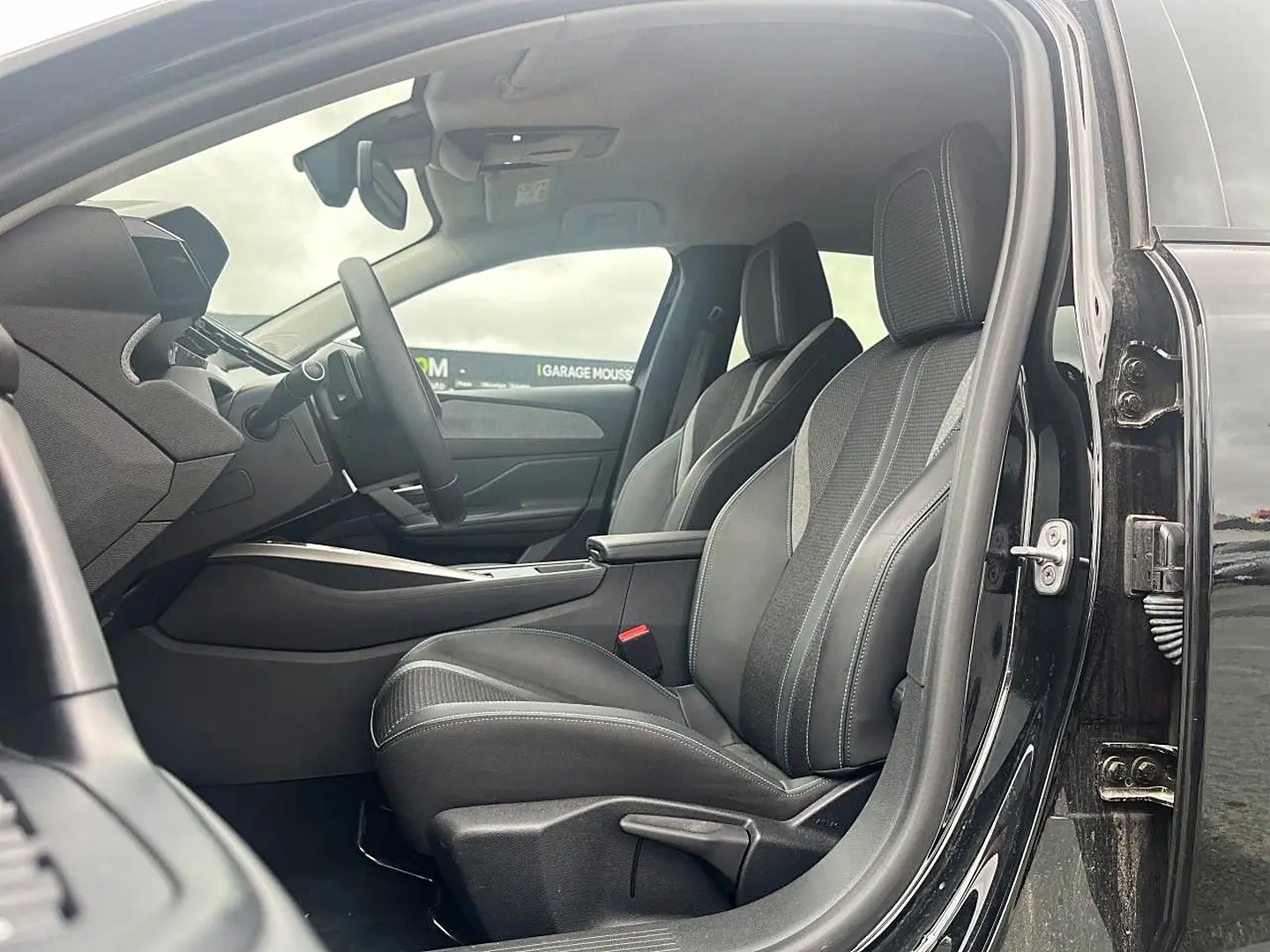 Intérieur de la Peugeot 308 1.5 BlueHDi 130 noir, vue côté gauche sur les sièges avant en tissu gris avec surpiqûres quartz.