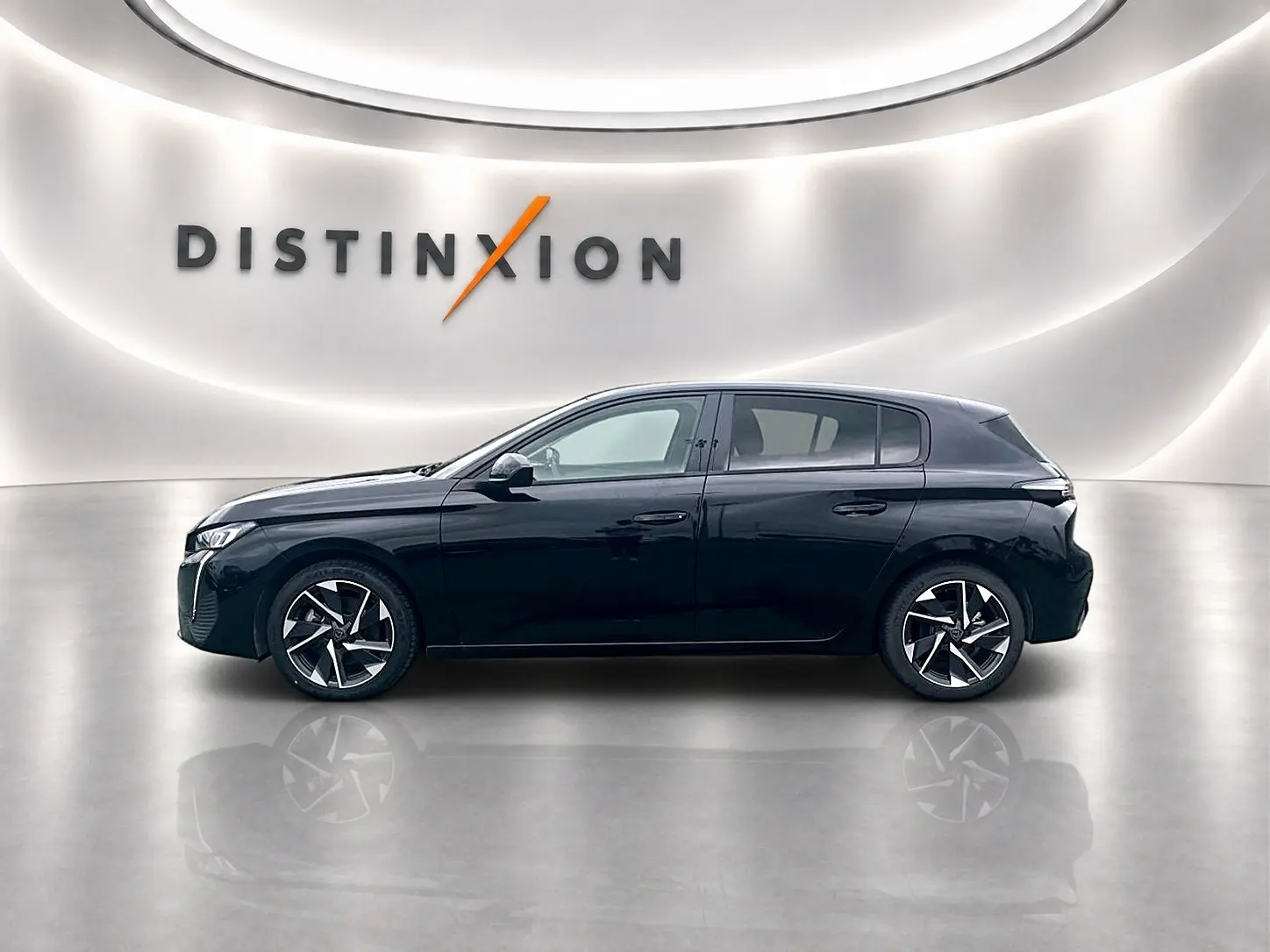 Profil droit d'une Peugeot 308 noire 2025 avec jantes alliage et lignes épurées dans un showroom lumineux.