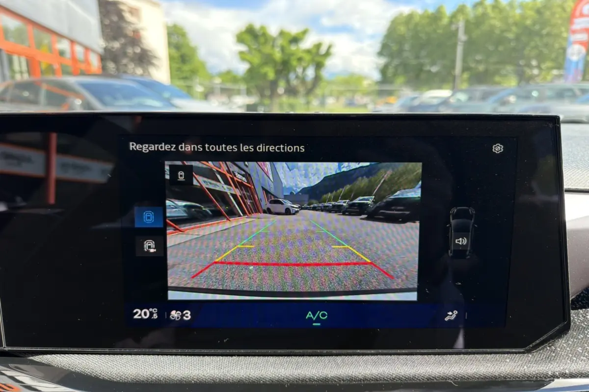 Affichage caméra de recul sur écran intérieur d'une Renault Clio blanc glacier, vue arrière avec lignes de guidage colorées.