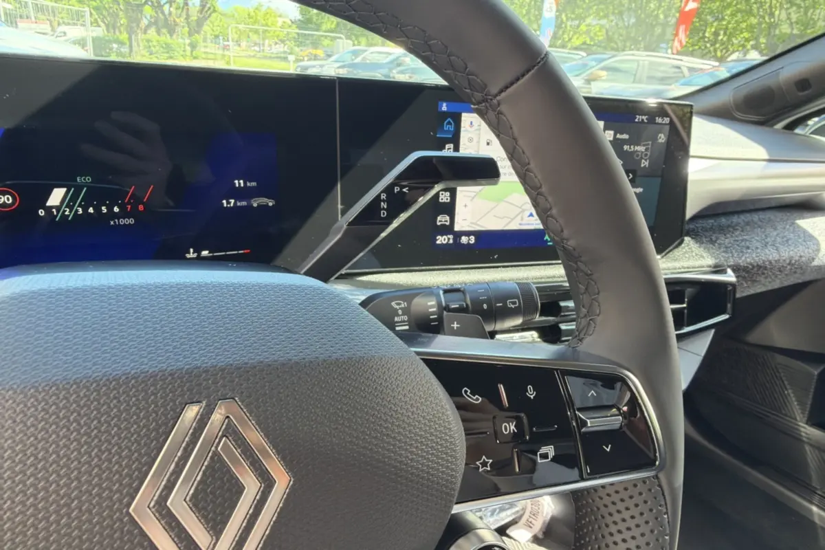 Gros plan sur le volant cuir grainé et le tableau de bord numérique avec écran tactile de la Renault Clio blanc glacier 2026.