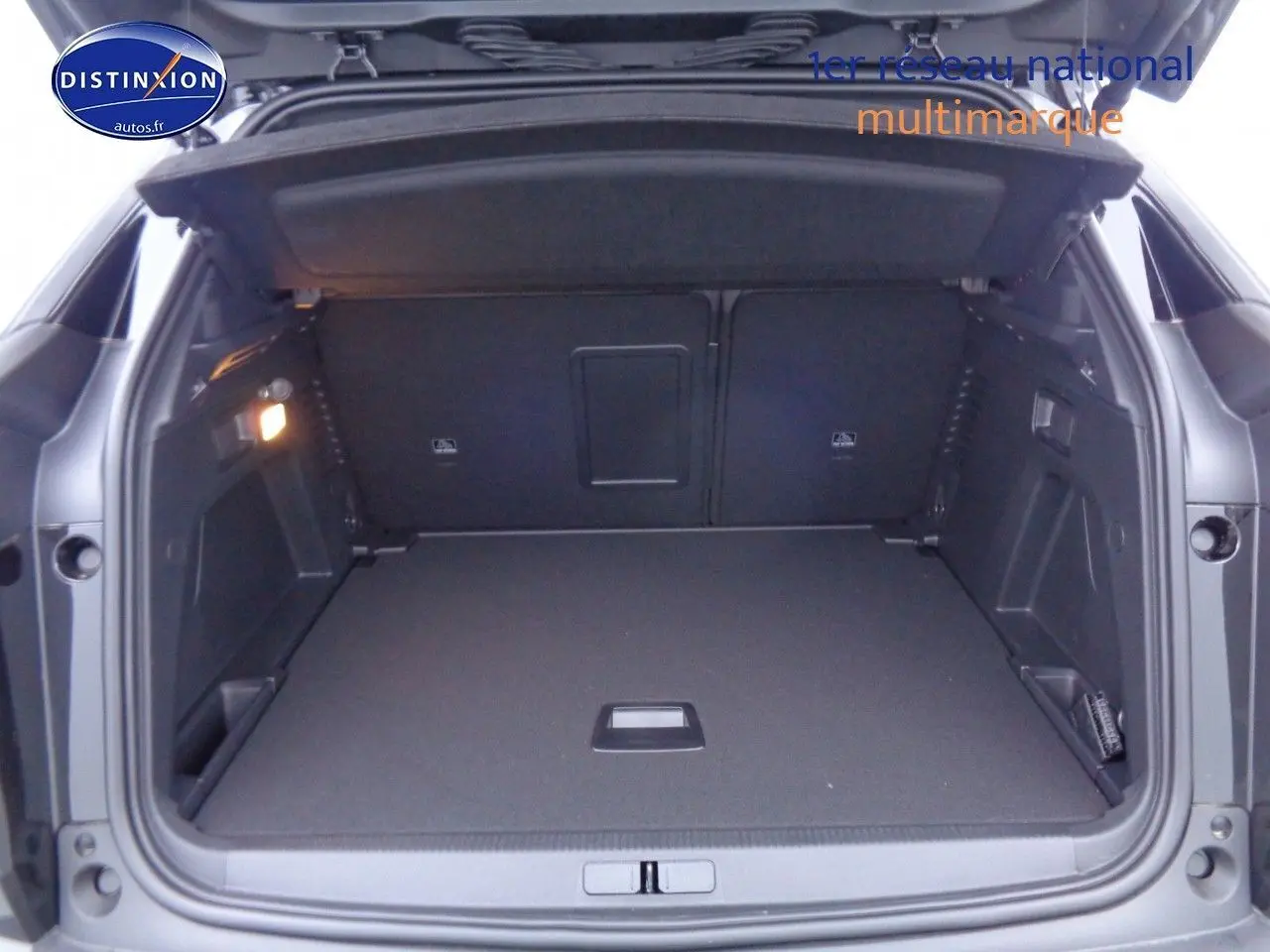 Coffre ouvert du Peugeot 3008 noir métal 2023, montrant un espace de chargement spacieux et bien éclairé.