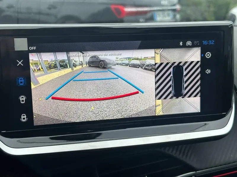 Écran de caméra de recul du Peugeot 208 1.2 Hybrid 110ch GT, affichant vue arrière avec lignes de guidage colorées.