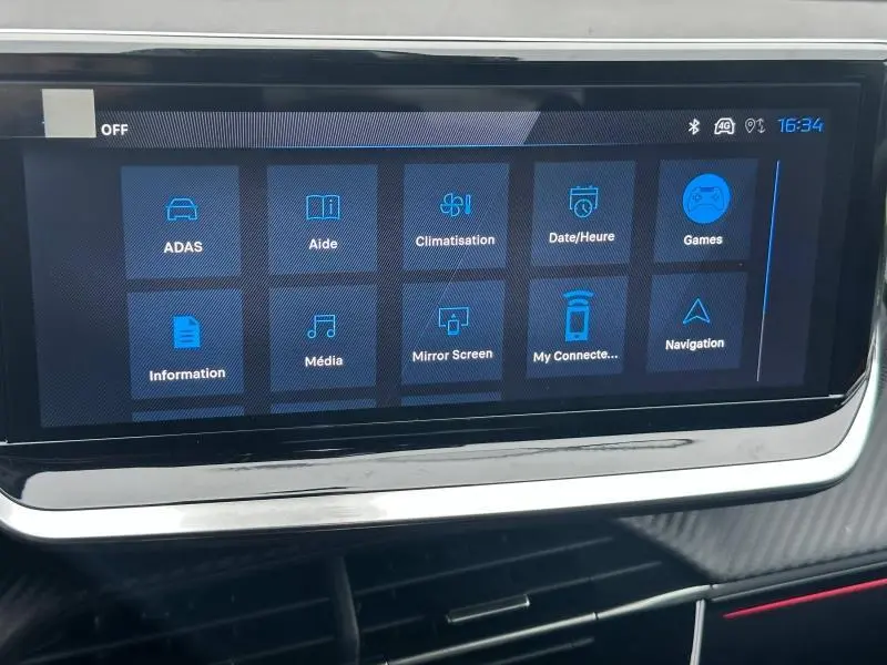 Écran tactile central du tableau de bord de la Peugeot 208 1.2 Hybrid 110ch GT 2025, affichant les menus connectés.