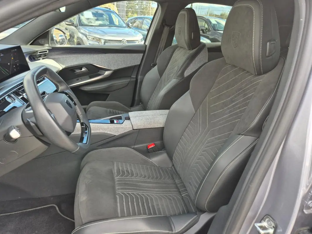 Vue intérieure côté conducteur du Peugeot 3008 Hybrid 136 e-DCS6 GT 2024 gris clair, avec sièges en alcantara et cockpit numérique.