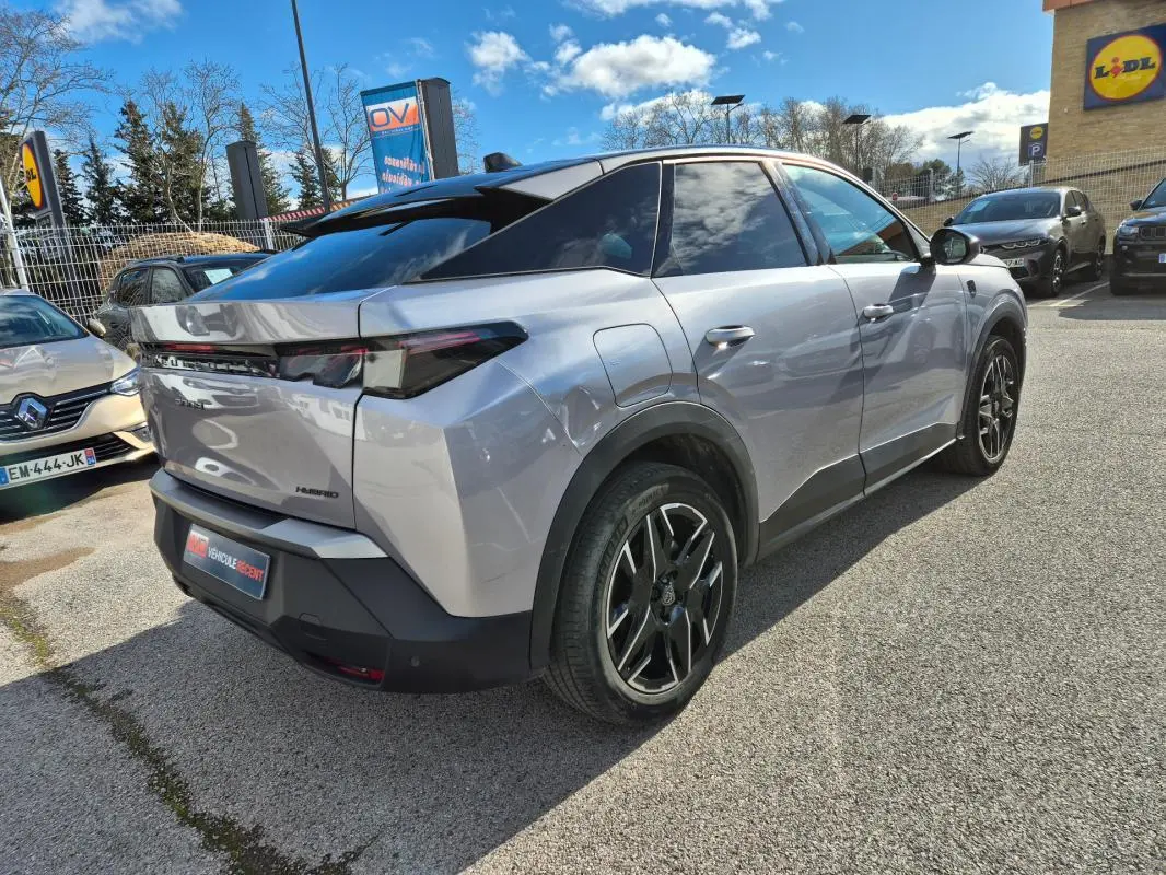 Peugeot 3008 Hybrid gris clair en 3/4 arrière droit, avec jantes alliage 19 pouces et toit noir contrasté.