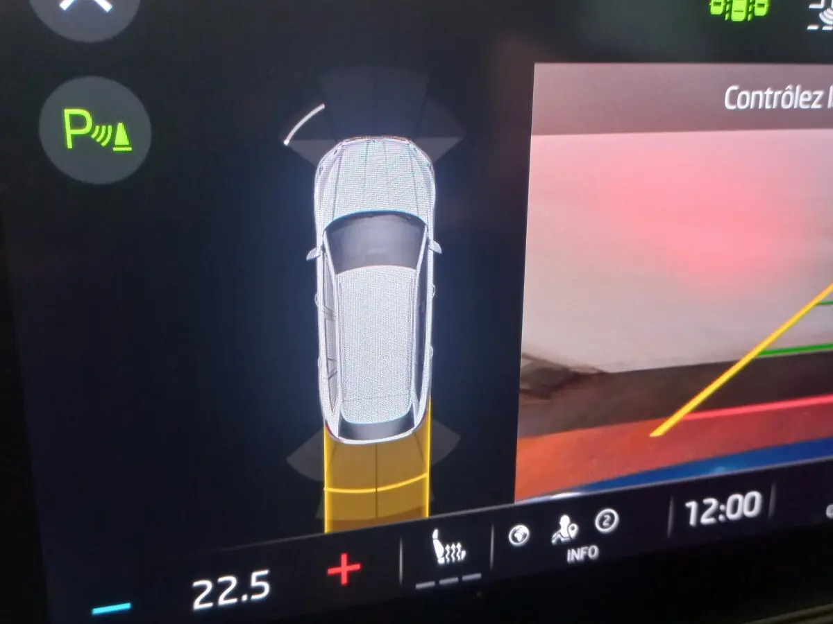 Affichage numérique intérieur montrant la Skoda Octavia hybride en vue aérienne avec aide au stationnement active.