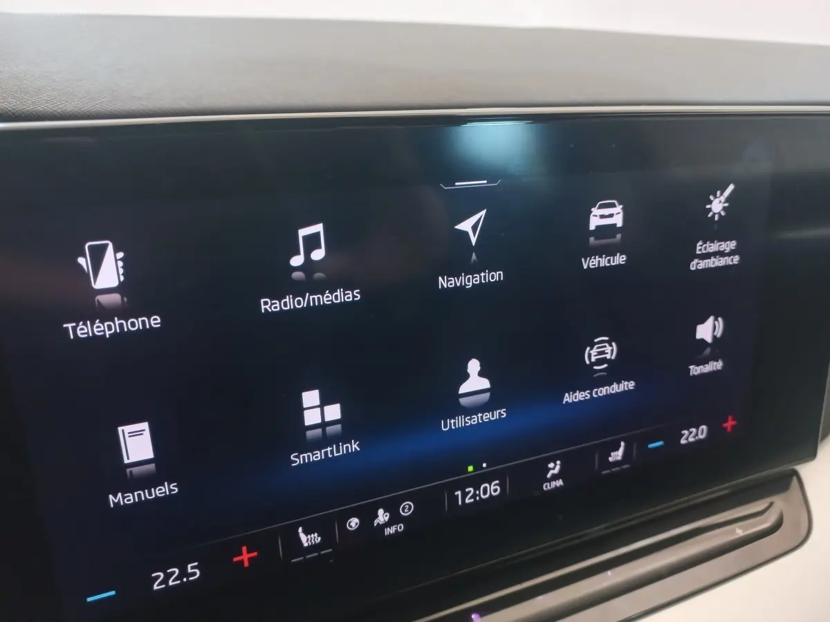Écran tactile central de la Skoda Octavia bleu, affichant les menus de navigation et médias en intérieur.