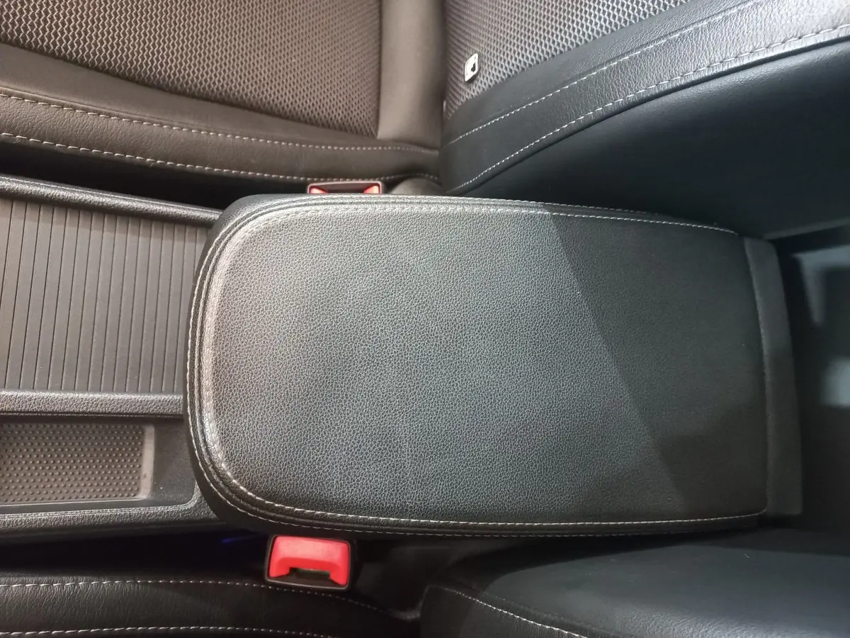 Vue rapprochée de l'accoudoir central en cuir noir avec surpiqûres blanches dans l'habitacle d'une Skoda Octavia 2022.