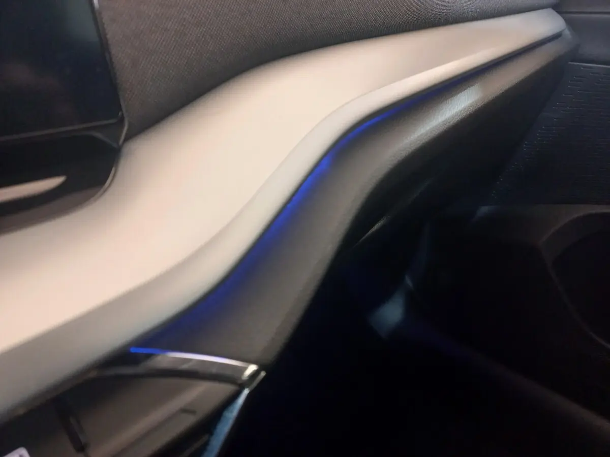 Détail intérieur du tableau de bord beige et noir de la Skoda Octavia 1.5 TSI mHEV 2022 avec éclairage d’ambiance bleu.