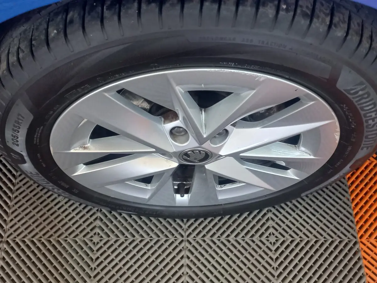 Gros plan sur la jante alliage argentée et pneu Bridgestone d'une Skoda Octavia bleue, vue de dessus.