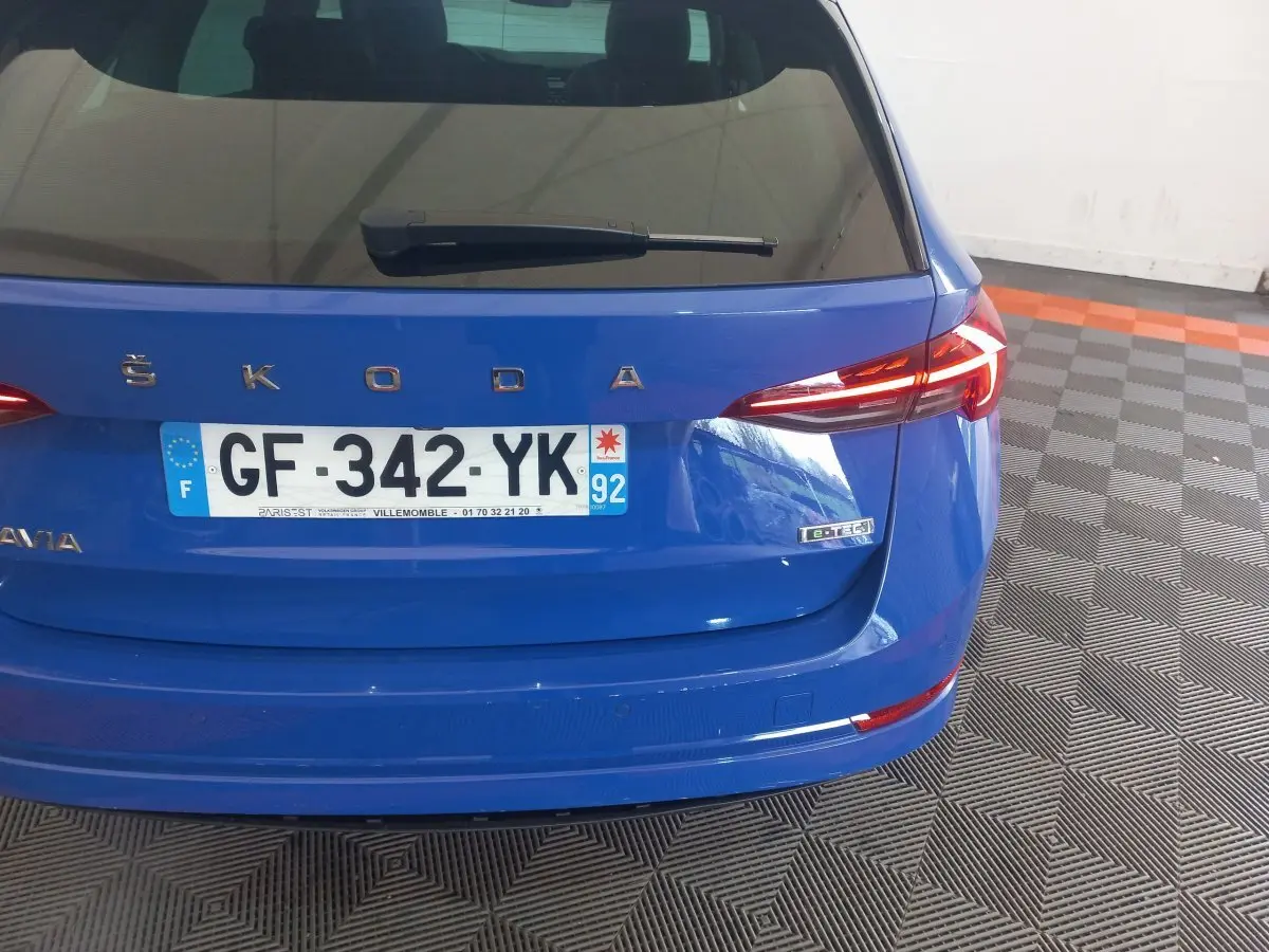 Vue arrière d'une Skoda Octavia bleu avec plaque française et badge e-TEC sur un sol à motifs géométriques.